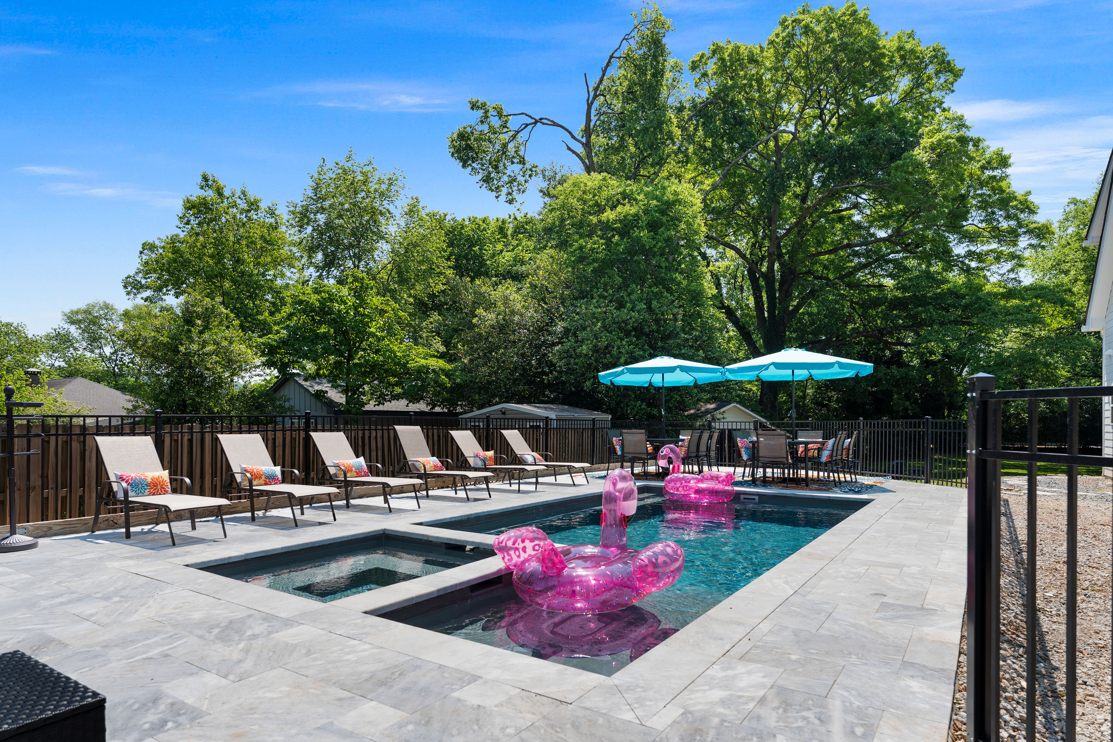 Pool with flamingo floats and sun loungers